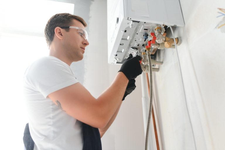 a man wearing goggles and gloves working on a gas heater